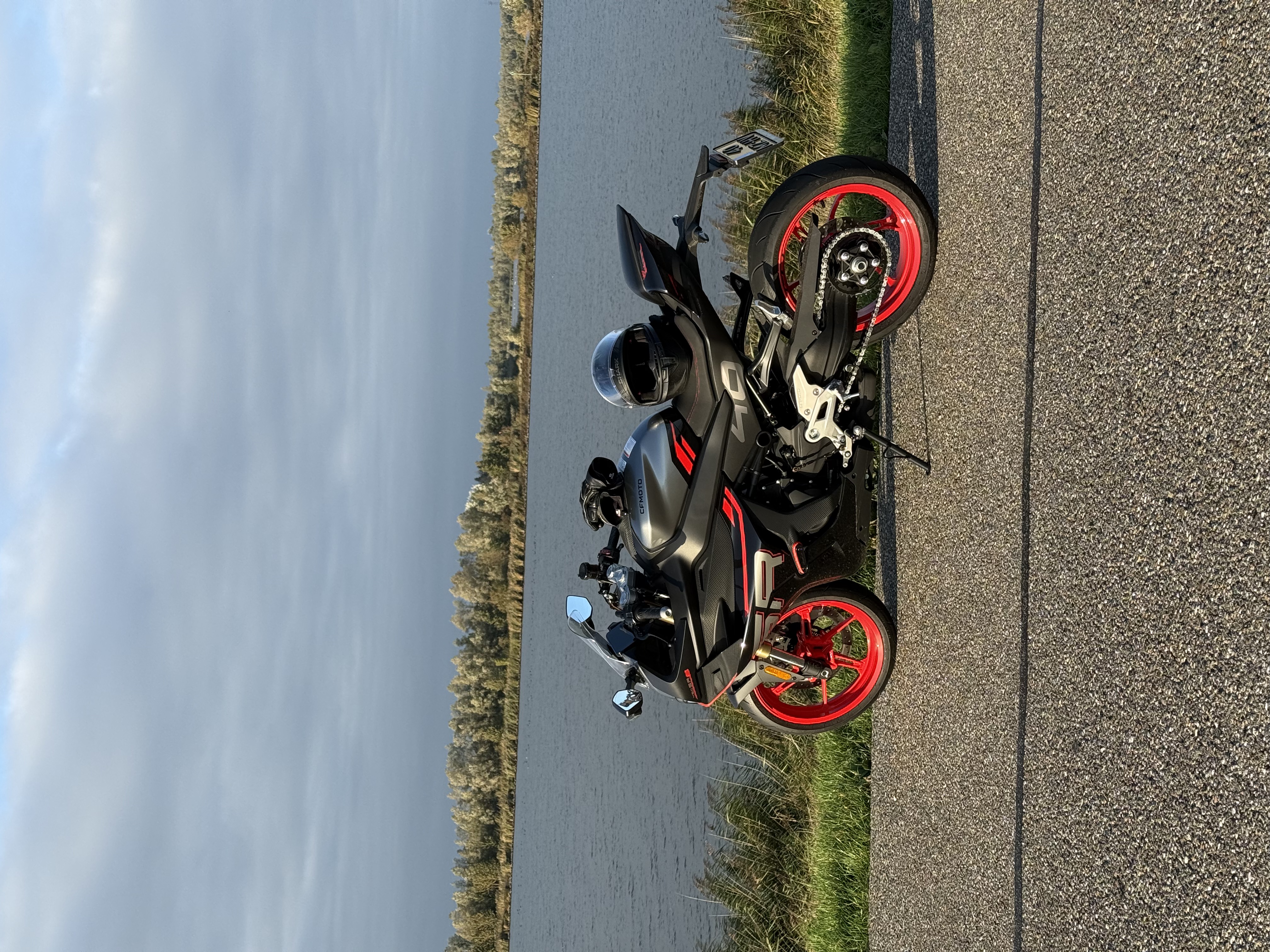 Plaatje van een motor met een meer op de achtergrond